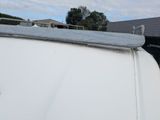 a white van parked in a yard with a sky background