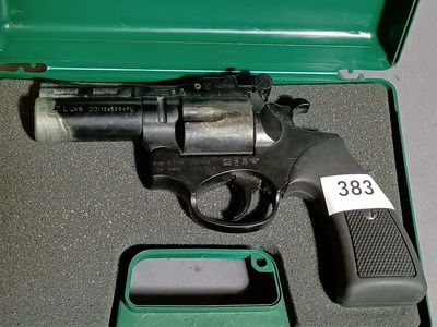 a gun in a green case with a tag on it