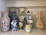 many vases that are sitting on a shelf together