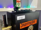 un petit réfrigérateur noir sur lequel est posée une bouteille de bière