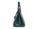 a green crocodile skin handbag on a white background