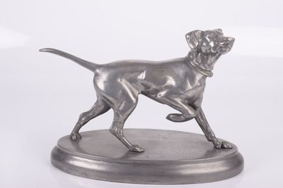 statue d'un chien en train de courir, posée sur un socle, sur fond blanc