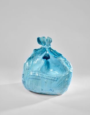 un sac bleu rempli de nourriture posé sur une surface blanche