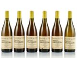 six bottles of wine are lined up on a white surface