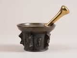a brass mortar with a brass pestula in it