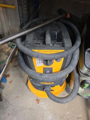 un aspirateur jaune et noir posé dans un garage
