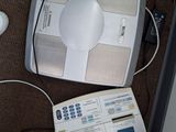 une balance électronique blanche posée par terre à côté d'une souris