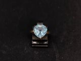 a close up of a ring with a heart shaped blue topaz stone