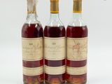 trois bouteilles de vin posées les unes à côté des autres sur une surface blanche