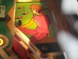 a close up of a pinball machine with a girl on it