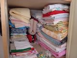 une armoire remplie de vêtements pliés et d'une peluche