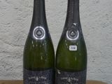 deux bouteilles de vin posées sur une table l'une à côté de l'autre