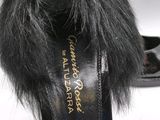 the woman is wearing a pair of black shoes with fur on them