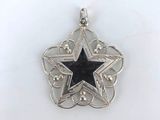a close up of a star shaped pendant on a white surface