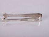 un gros plan sur une paire de pinces posées sur une surface blanche