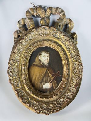 une vieille photo d'un homme dans un cadre doré orné d'un oiseau