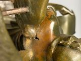 une statue en bronze représentant un oiseau avec un oisillon sur le dos