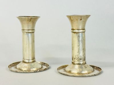 two silver candlesticks that are sitting on a table