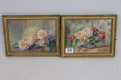 two paintings of flowers in a gold frame on a white wall