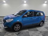 La voiture bleue est garée dans une grande pièce au sol à carreaux.