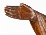 a wooden statue of a person holding his hand out