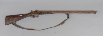 un vieux fusil avec une poignée en bois sur une surface blanche