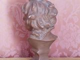 a statue of a dog on a pedestal in front of a pink wall