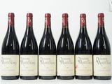 six bouteilles de vin sont alignées sur une surface blanche