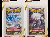 two packs of pokemon trading cards in plastic packaging on a black background