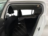 a white car with its door open and luggage in the back seat