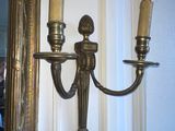 two lamps that are on the wall next to a mirror