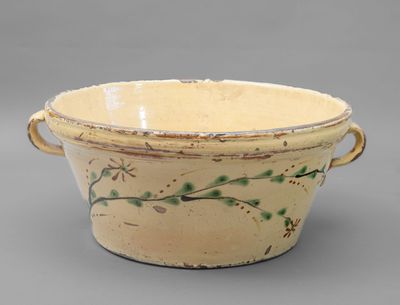 a small bowl with a handle on a gray surface