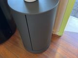 a black trash can sitting on top of a wooden table