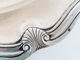 an antique silver plate with a decorative design on the edge of it