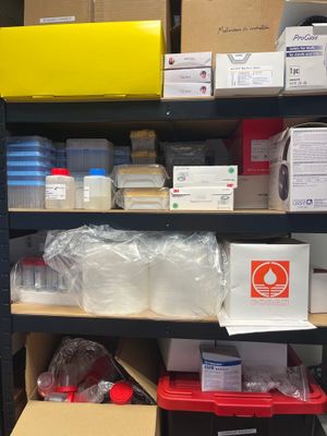 many boxes and containers on a shelf in a room