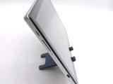 a tablet computer sitting on a stand on a white surface