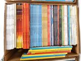 many books in a cardboard box on a white background