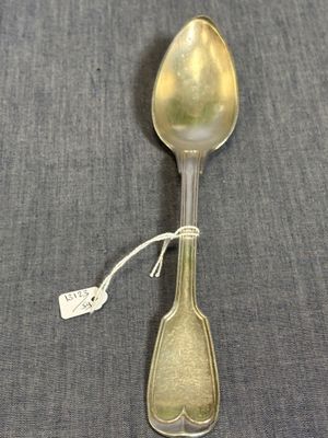 une cuillère en argent avec une étiquette, posée sur une table