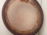 a brown bowl sitting on a white surface