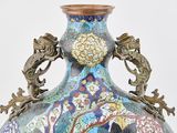 a vase that has a dragon handle on it