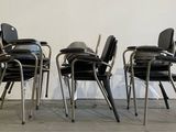 four black chairs sitting in front of a white wall