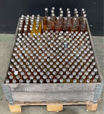 many bottles of beer in a wooden crate on the floor
