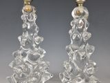 paire de bougeoirs en verre transparent ornés de figures sculptées