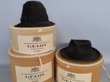trois chapeaux noirs sont posés sur une boîte en carton