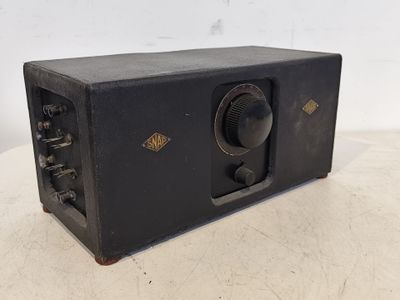 une vieille radio posée sur une table, sur fond blanc