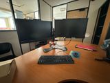 a desk with two monitors and a keyboard on it