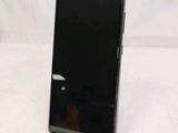 the back of a black cell phone sitting on top of a white table