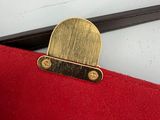 a red bag with a gold handle and a black handle