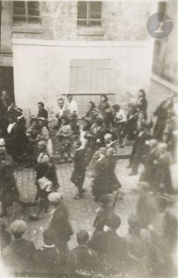 une photo en noir et blanc d'un groupe de personnes dans une cour