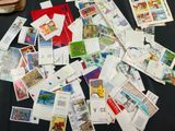 a pile of stamps on a table next to a bag of luggage